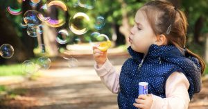 Kid Blowing Bubbles in Park